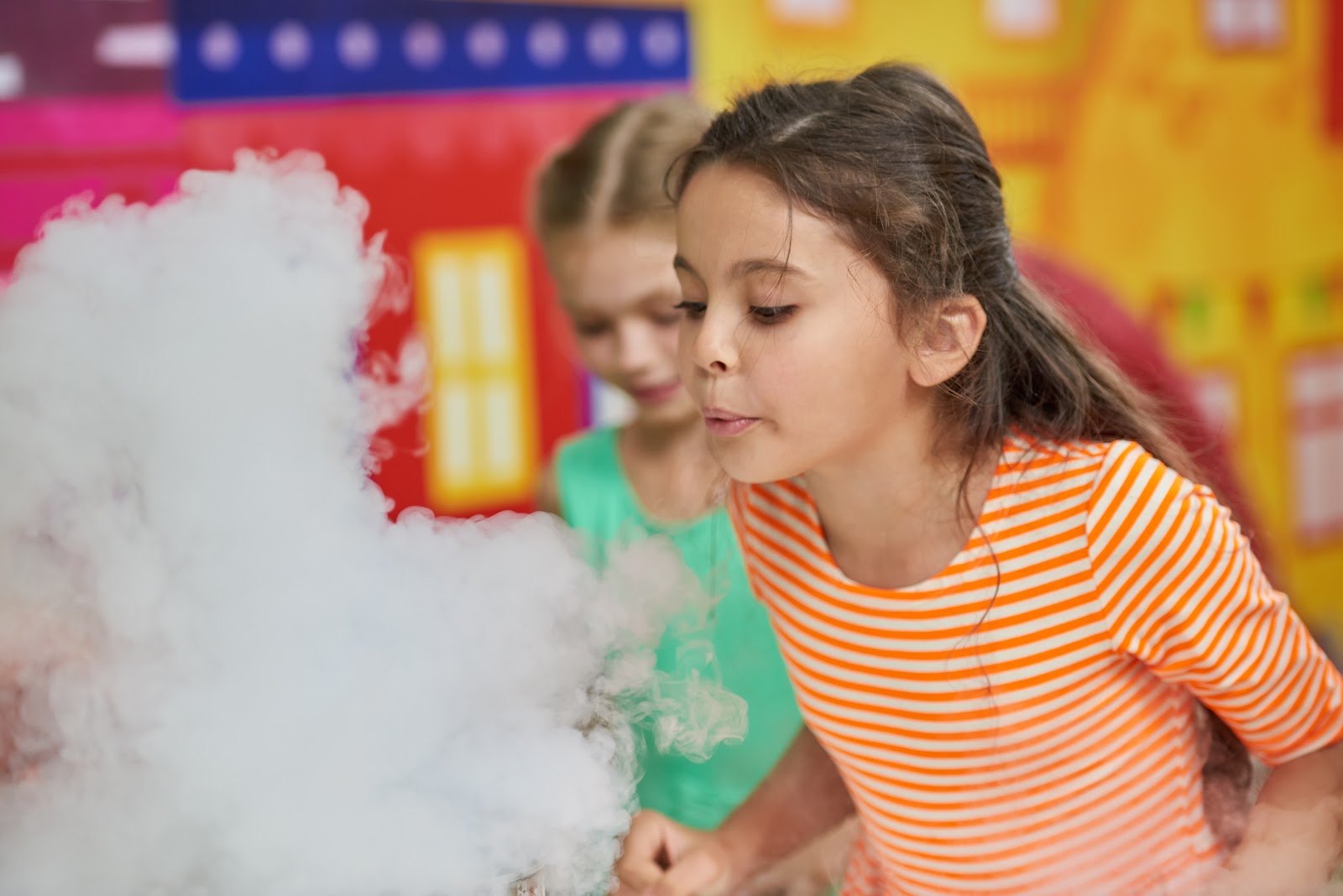 Kids watching a cloud of vapor rise from a science demonstration