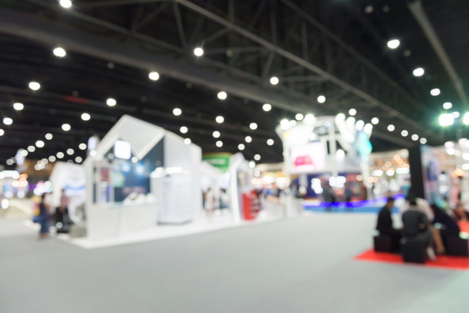 A busy trade show exhibition hall, softly out of focus